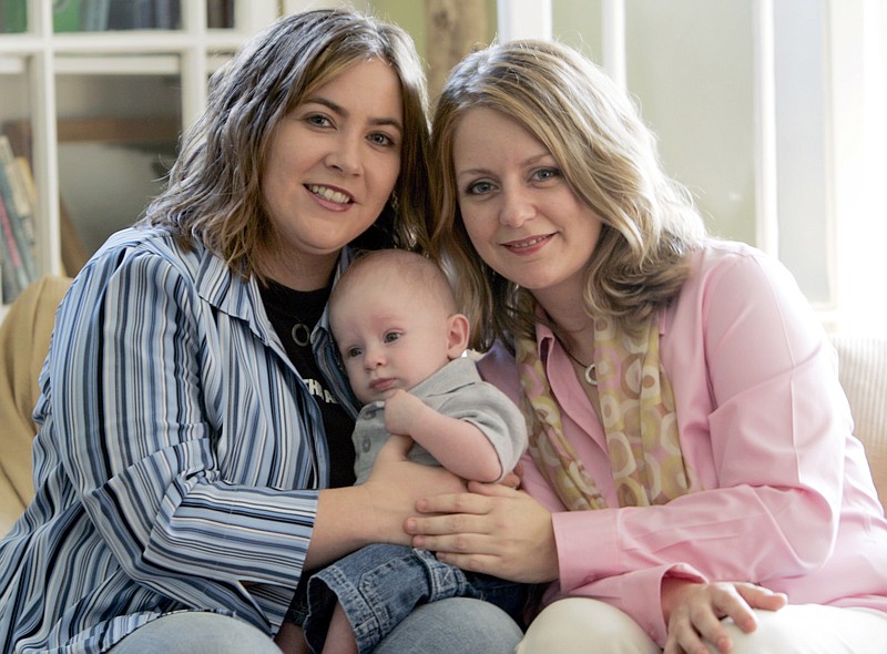 In this May 4, 2006, file photo, Cari Searcy, left, and Kim McKeand pose for a portrait with their son Khaya in Mobile, Ala.