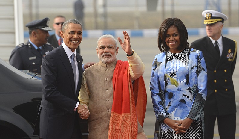 U.S. President Barack Obama shakes hand with Indian Prime Minister Narendra Modi, as first lady Michelle Obama stand beside them, upon arrival at the Palam Air Force Station in New Delhi, India, on Sunday, Jan. 25, 2015. 