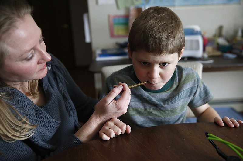 Nicole Gross uses an oral syringe to give her son Chase his daily dose of a medical marijuana oil, known as Charlotte's Web, at their home in Colorado Springs, Colo., in this Jan. 1, 2015, photo.