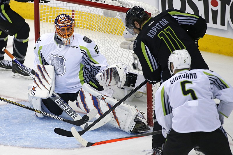 Team Toews goalie Jaroslav Halak of the New York Islanders watches a rebound as Team Foligno's Anze Kopitar (11) of the Los Angeles Kings tries to get his stick on it with Mark Giordano (5) of the Calgary Flames defending during the third period of the NHL All-Star hockey game in Columbus, Ohio, Sunday, Jan. 25, 2015.