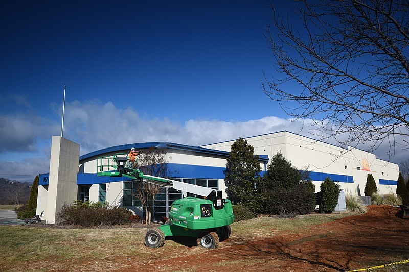 A worker pressure washes the facade of 767 River Terminal Road Tuesday as Babcock and Wilcox prepares for business at the former East Tech location on River Terminal Road near Amnicola Highway.