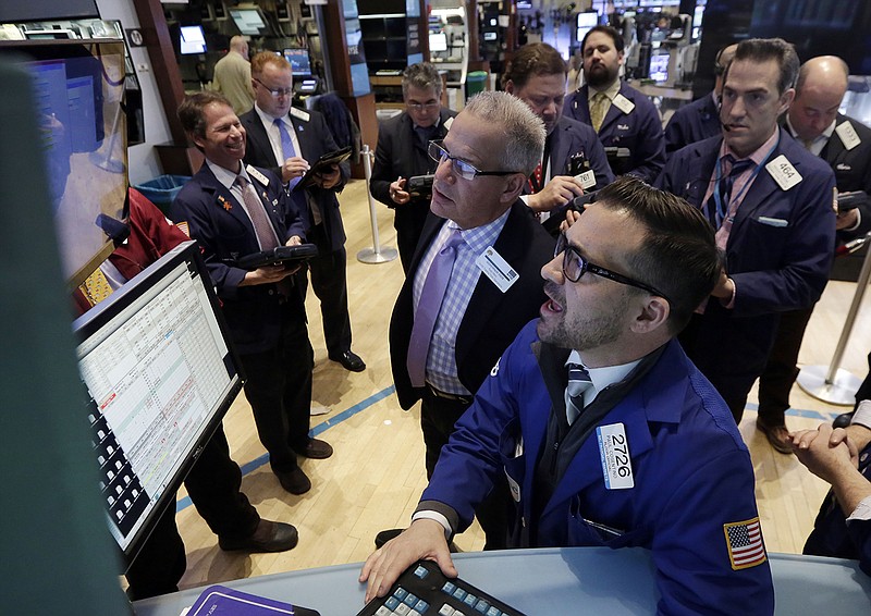 Specialist Paul Cosentino, foreground center, works at the post that handles Cliffs Natural Resources, on the floor of the New York Stock Exchange on Tuesday.