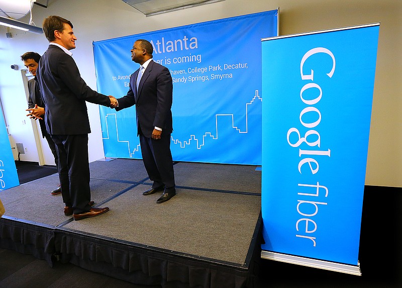 
              Tom Lowry, left, head of the Google Atlanta office, shakes hands with Atlanta Mayor Kasim Reed at the conclusion of a press conference announcing the launch of Google Fiber in Atlanta, one of four cities also including Charlotte, Raleigh-Durham, and Nashville on Tuesday, Jan. 27, 2015, in Atlanta.  (AP Photo/Atlanta Journal-Constitution, Curtis Compton)  MARIETTA DAILY OUT; GWINNETT DAILY POST OUT; LOCAL TELEVISION OUT; WXIA-TV OUT; WGCL-TV OUT
            