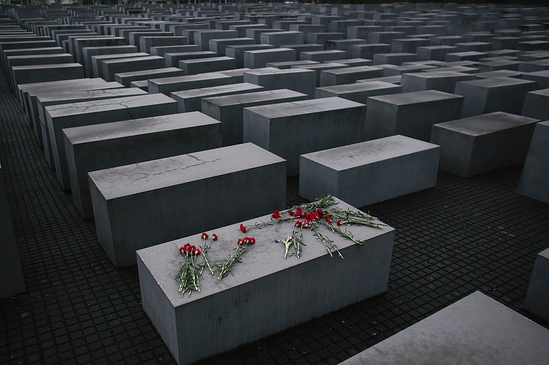 Flowers lie  on a concrete slab of the Holocaust Memorial to mark the International Holocaust Remembrance Day and commemorating the 70th anniversary of the liberation of the Nazi Auschwitz death camp in Berlin, Tuesday, Jan. 27, 2015. 