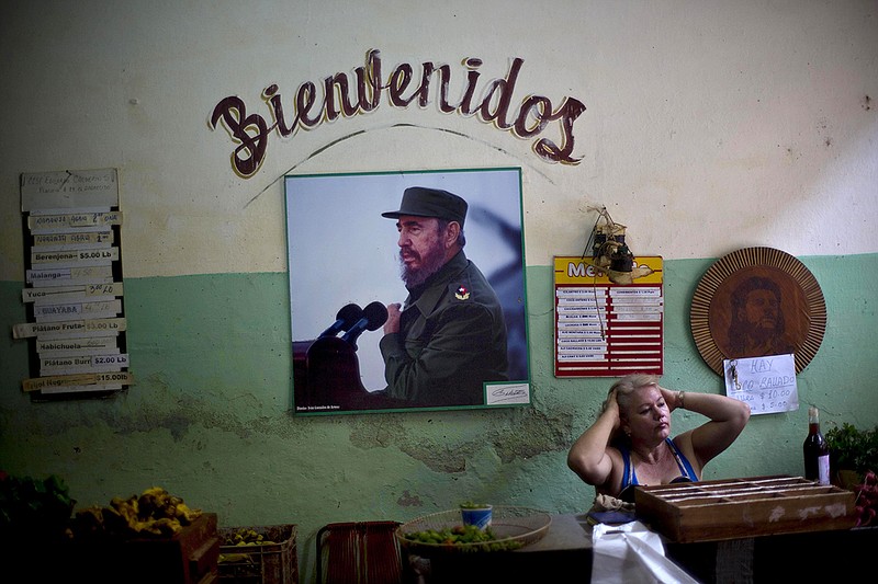 In this Dec. 26, 2014, file photo, a photograph of Fidel Castro hangs under the Spanish word "Welcome" on the wall at a state-run food market in Havana, Cuba.