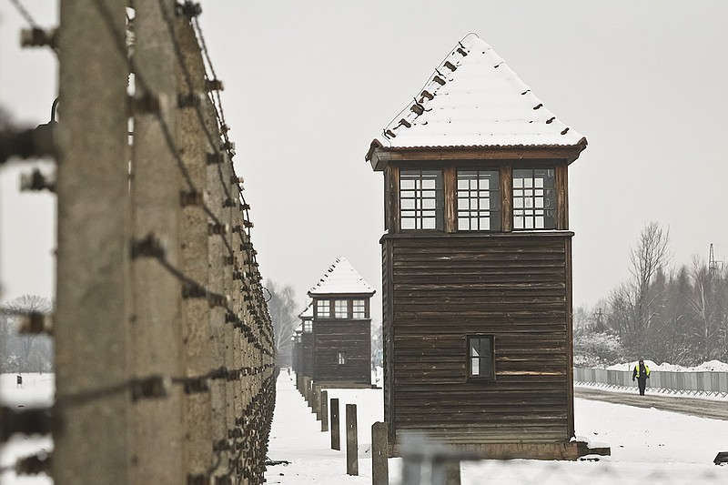 Barbed wire fences and guard towers surround the access road into the Birkenau Nazi death camp in Oswiecim, Poland, Monday, Jan. 26, 2015.