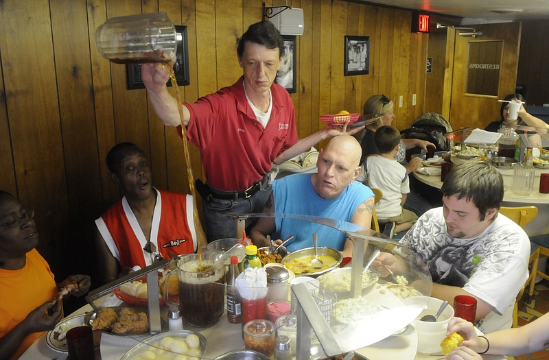 Server Jamie Ellis, center, pours tea for customers Phyllis Bell, Anthony Harshaw, Gary Johnson and Justin Wood, from left, in Bea's Restaurant Thursday. The restaurant offered meals for a dollar to celebrate the restaurant's 60th anniversary celebration.