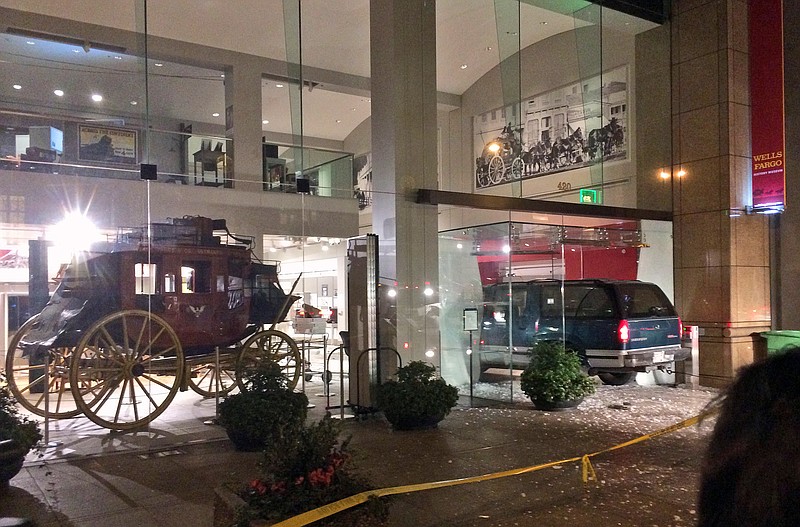 
              A vehicle is seen smashed into the window of the Wells Fargo History Museum in downtown San Francisco, Tuesday, Jan. 27, 2015. Thieves in the SUV smashed through the glass doors of the museum and made off with gold nuggets on display. (AP Photo/Kristin Bender)
            