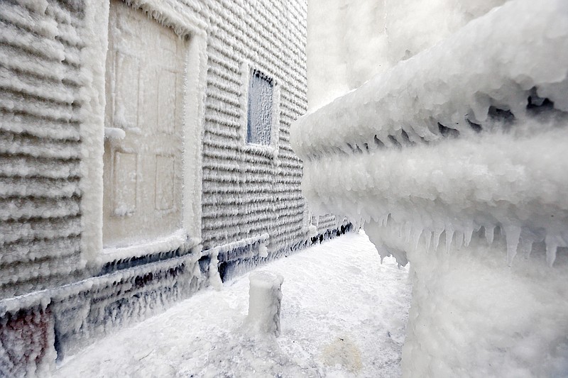 Frozen sea spray coats houses the day after a winter storm in Scituate, Mass., Wednesday, Jan. 28, 2015.  Residents of Massachusetts woke up Wednesday to cars buried in several feet of snow, and secondary roads that remain covered. 