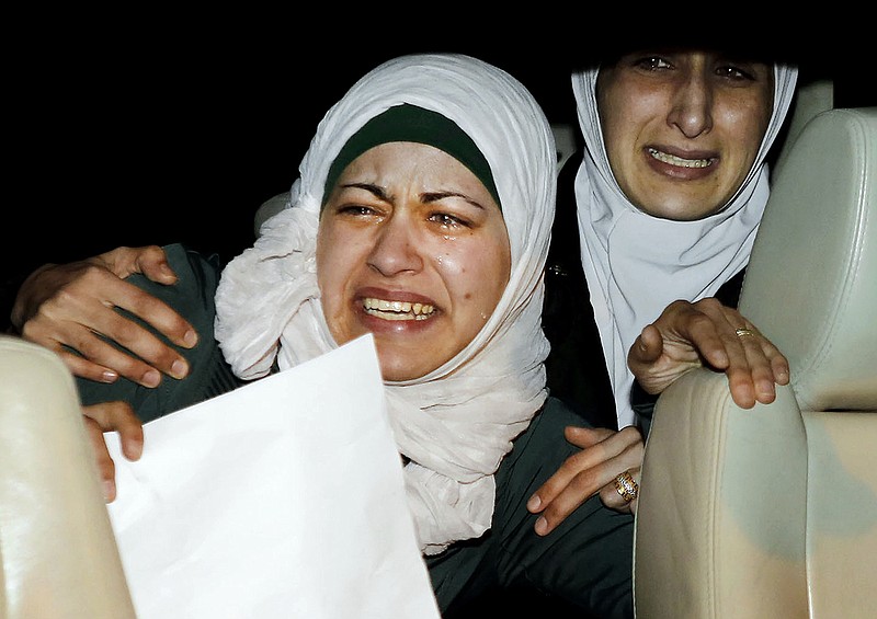 The sister, right, and wife, left, of Jordanian pilot, Lt. Muath al-Kaseasbeh, who is held by the Islamic State group militants, cry as they ride a car during a protest in front of the Royal Palace in Amman, Jordan, Wednesday, Jan. 28, 2015.