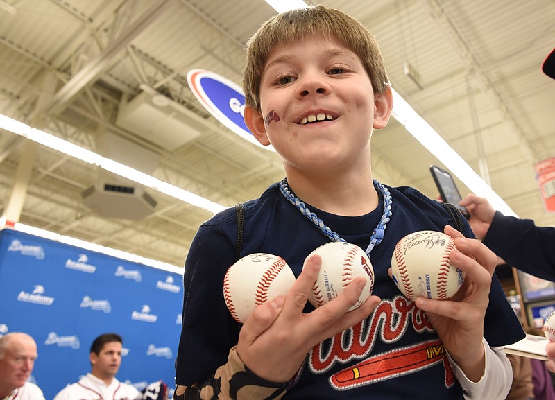 Logan Carmona, 10, is overjoyed with his signed baseballs after attending the Braves Caravan event Thursday at the Hamilton Place Academy Sports and Outdoors store. "He's going to put them in his man cave, " Kelly Gardner, his mother, said.