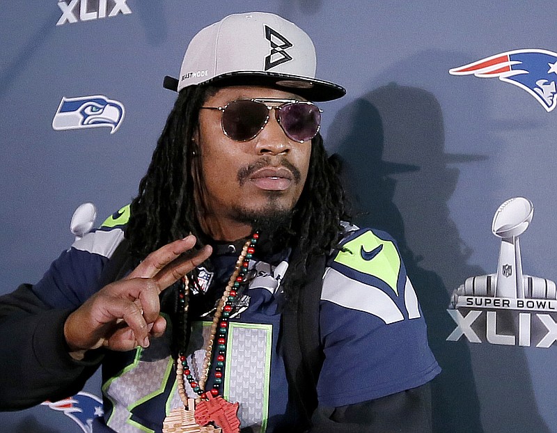 
              FILE - In this Wednesday Jan. 28, 2015, file photo, Seattle Seahawks' Marshawn Lynch gestures at a news conference for NFL football's Super Bowl XLIX in Phoenix. The NFL may not like those "Beast Mode" caps Lynch has been wearing during his Super Bowl press appearances, but the fans apparently do. As the league reportedly considers fining Lynch for promoting an unauthorized brand, the New Era Cap Co. is busy making more of the caps after they sold out on Lynch's website. (AP Photo/Matt York, File)
            