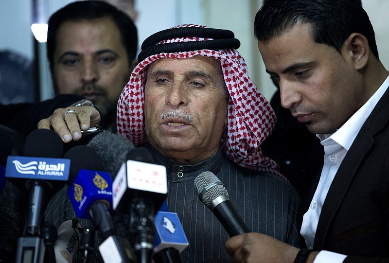 Safi al-Kaseasbeh, center, father of Jordanian pilot, Lt. Muath al-Kaseasbeh, who is held by the Islamic State group militants, reads a statement for the media urging his son's captors to have mercy on a fellow Muslim and spare his life, at the captured pilot's tribal gathering divan, in Amman, Jordan, Thursday, Jan. 29, 2015.