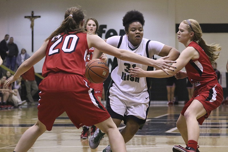 Notre Dame's Meme Siler (31) dribbles through Signal Mountain defenders Maia Rackel (20) and Stephanie Peterson (1) during their game at the Fighting Irish's home gym on Friday, Jan. 30, 2015. The Irish won over the Eagles in the last seconds of play with a final score of 54-53. 