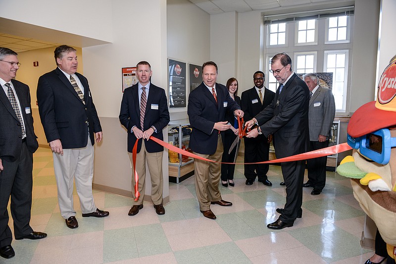 Krystal Chief Operating Officer Gary Clough (left) and Dean of UTC College of Business, Dr. Robert Dooley, right, commemorate the opening of the display with a ribbon cutting.