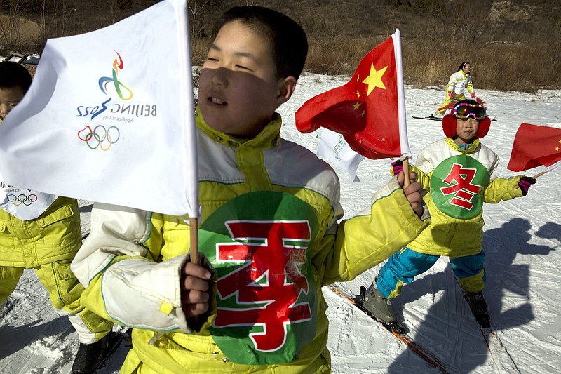 
              In this photo taken Friday, Jan. 16, 2015, Chinese schoolchildren waves their national flags and the 2022 Olympic bid logo to show their support at the ski resort in Yanqing, a suburb of Beijing, where the speed mavens of Alpine skiing and the sliding events - bobsled, skeleton and luge - have been proposed to be held in the bid for the 2022 Winter Olympics. Chinese authorities are making the final push in its bid for the 2022 Winter Olympics that will make the Chinese capital Beijing the first city to hold both the summer and winter Olympics. (AP Photo/Ng Han Guan)
            