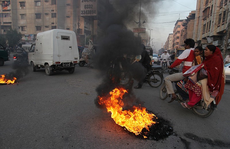 Pakistani protesters burn tires to condemn a blast at a Shiite mosque, Friday, Jan. 30, 2015 in Karachi, Pakistan.