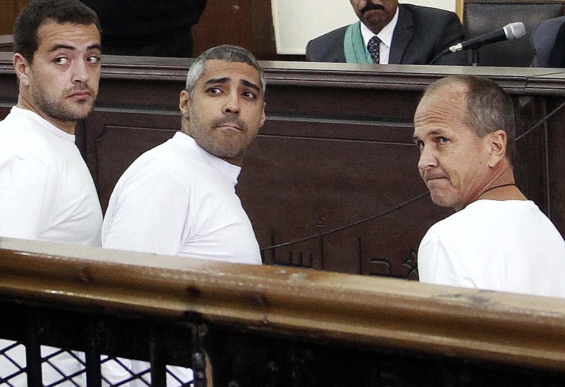 
              FILE - In this Monday, March 31, 2014 file photo, Al-Jazeera English producer Baher Mohamed, left, Canadian-Egyptian acting Cairo bureau chief Mohammed Fahmy, center, and correspondent Peter Greste, right, appear in court along with several other defendants during their trial on terror charges, in Cairo, Egypt. A senior Egyptian prison official and the country's official news agency say Greste has been freed from prison and is on his way to Cairo airport to leave the country. (AP Photo/Heba Elkholy, El Shorouk, File) EGYPT OUT
            