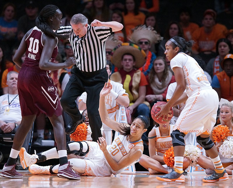 Tennessee's Isabelle Harrison, bottom, collides with an official after passing the ball to Tennessee's Ariel Massengale, right, during their game, Sunday, Feb. 1, 2015, in Knoxville.
