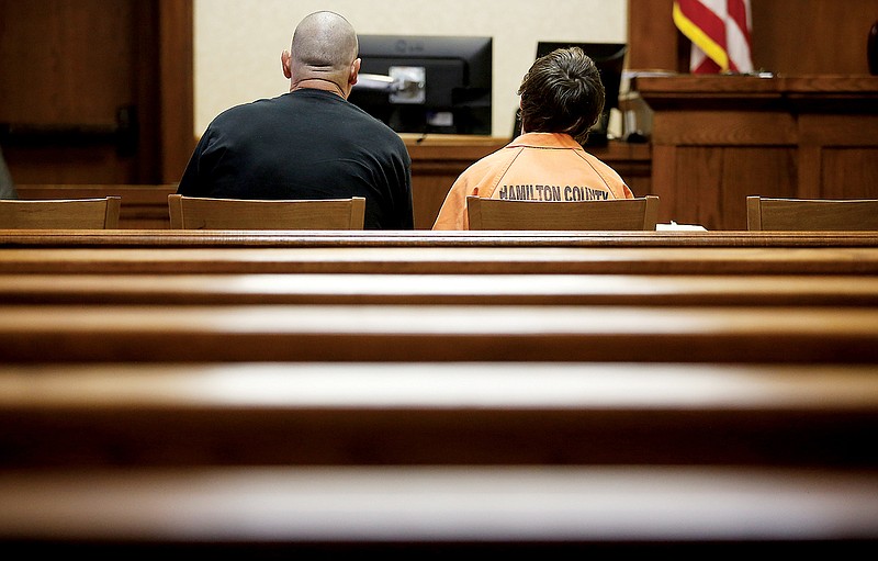 The juvenile charged along with two adult men in an April triple-murder in Lookout Valley sits with his father during a recess from a hearing recently in Hamilton County Juvenile Court Judge Rob Philyaw's courtroom in Chattanooga to determine whether he should be transferred to adult court.