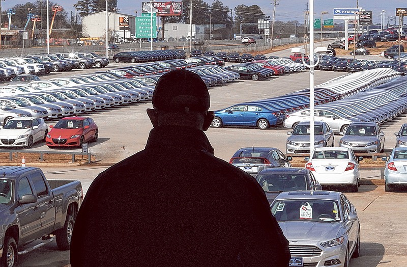 Trea Watson, a sales associate at Economy Honda, looks onto the lot while waiting for a customer on Monday. New car sales are forecast to be up 14 percent in January over a year ago, according to USA Today.