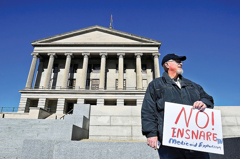 Mike Warner of Clarksville, Tenn., holds a sign outside the Capitol in Nashville on Tuesday. Inside, about 150 activists showed up to oppose Gov. Bill Haslam's new health care plan.