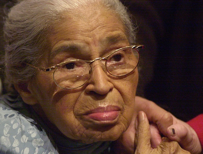 Civil rights pioneer Rosa Parks holds the hand of a well-wisher at a ceremony honoring the 46th anniversary of her arrest for civil disobedience, at the Henry Ford Museum in Dearborn, Mich., in this 2001, file photo.