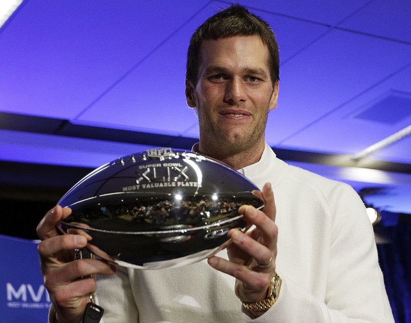 New England Patriots quarterback Tom Brady holds up his Pete Rozelle Trophy during a news conference after the NFL Super Bowl XLIX football game on Feb. 2, 2015, in Phoenix, Ariz. The Patriots beat the Seattle Seahawks  28-24. Brady was named the game's most valuable player.