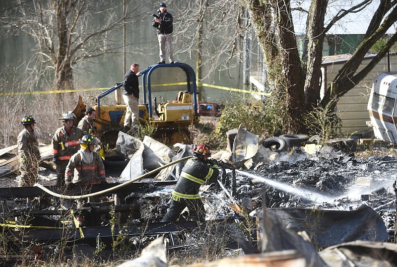 Firefighters work to extinguish hot spots Friday in a trailer on Suck Creek Road. Janice Atkinson, spokeswoman for the Hamilton County Sheriffs Department, said human remains are believed to have been found inside the trailer.  