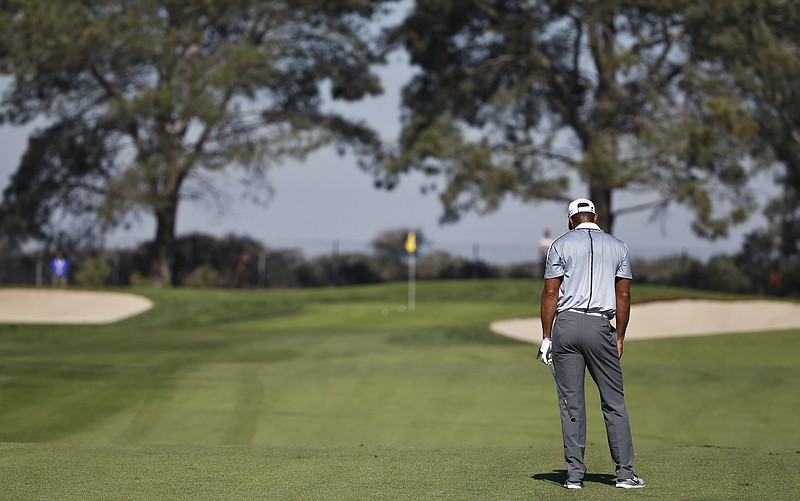 
              Tiger Woods looks down after misplaying his short iron approach to the far right of the 13th hole on the north course at Torrey Pines during the first round of the Farmers Insurance Open golf tournament Thursday, Feb. 5, 2015, in San Diego. (AP Photo/Lenny Ignelzi)
            