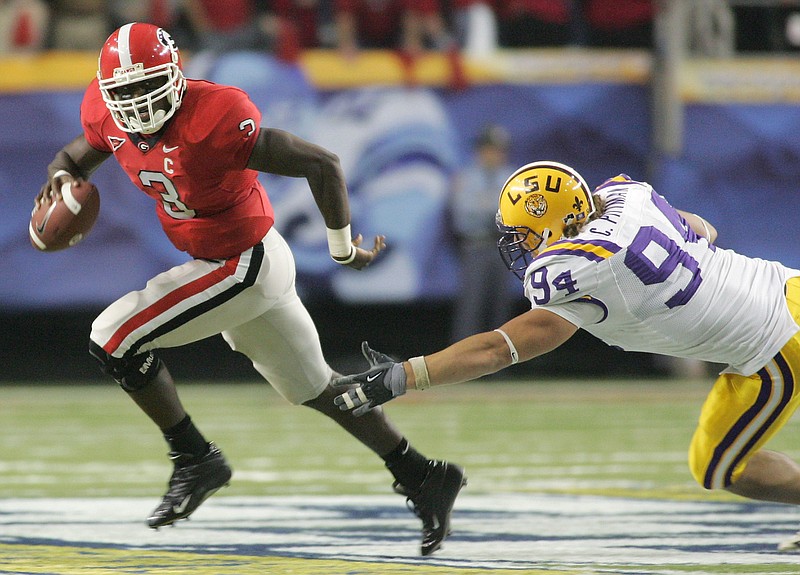 Georgia quarterback D.J. Shockley, left, eludes Louisiana State University's Chase Pitman during the second half of the Bulldogs 34-14 win in the Southeastern Conference Championship game Saturday Dec. 3, 2005, in Atlanta.