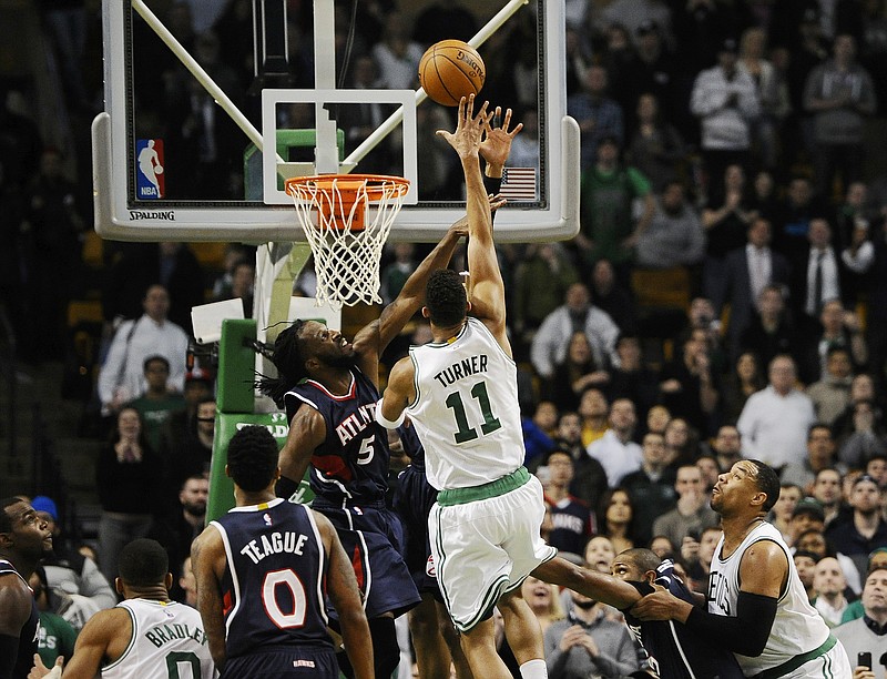 Boston Celtics' Evan Turner (11) shoots the game-winning basket over Atlanta Hawks' DeMarre Carroll (5) with 0.2 seconds left on the clock in the second half of their game Wednesday, Feb. 11, 2015, in Boston. 