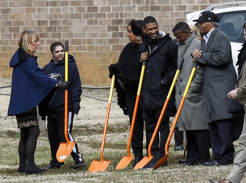 R&B artist Usher, third from right, stands with a group at a dedication Thursday, Feb. 12, 2015, during a visit to Orange Grove Center in Chattanooga, Tenn. The artist visited Chattanooga today, beginning at Dalewood Middle School.