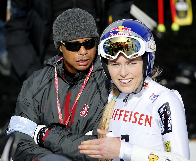 Tiger Woods, left, watches United States' Lindsey Vonn, right, during the women's giant slalom competition at the alpine skiing world championships on Thursday, Feb. 12, 2015, in Beaver Creek, Colo.