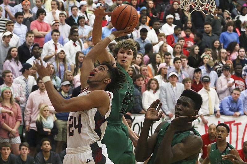 Ooltewah's Kobe Jones (24) shoots as East Hamilton's Cody Heard (25) and Tracy Thompson (2) attempt to block during the district 5-AAA tournament at the Owl's home court on Friday, Feb. 13, 2015. The Owls won over the Hurricanes with a final score of 42-35.