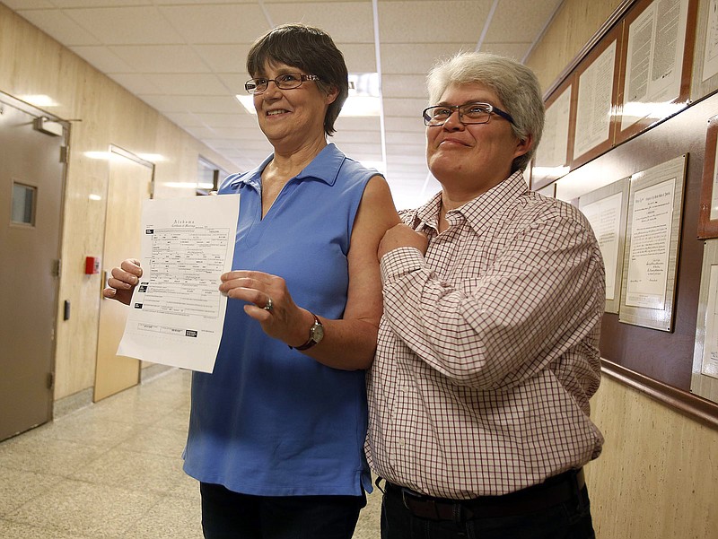Angela Channell, right, and Dawn Hicks, left, display their marriage license for friends, supporters and the media on Friday, Feb. 13, 2015. Channell and Hicks were the first couple to apply for and receive a marriage license from Tuscaloosa county for a same sex marriage. 