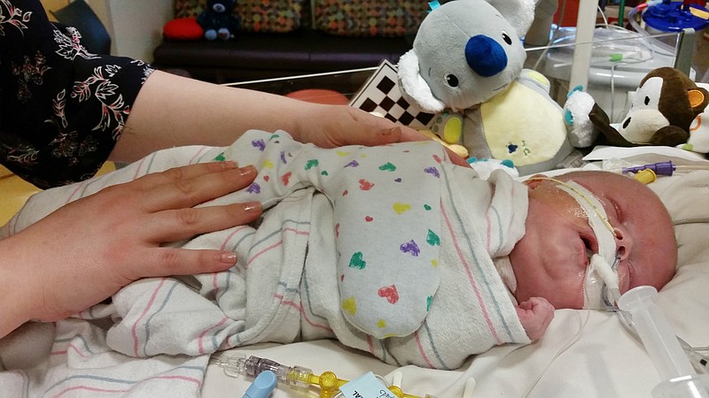 
              Caylyn Otto places her hands on her son, Oliver, at the Phoenix Children's Hospital in Phoenix on Friday, Feb. 13, 2015. Born nearly seven weeks early, the baby is one of the youngest heart transplant recipients at Phoenix Children's Hospital. Doctors say Oliver, who was due Feb. 20, has been doing remarkably well post-transplant. (AP Photo/Terry Tang)
            