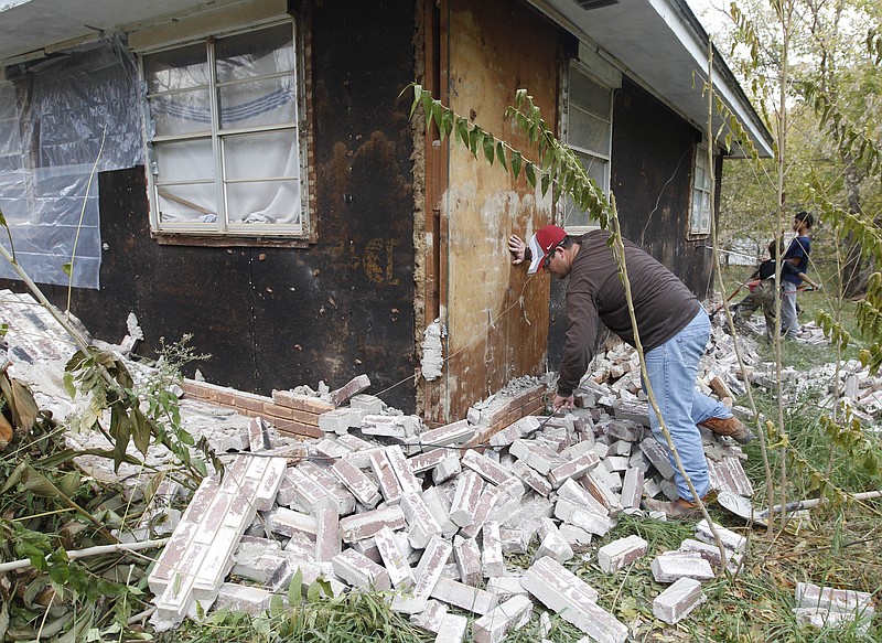 Chad Devereaux examines bricks that fell from three sides of his in-laws home in Sparks, Okla., after two earthquakes hit the area in less than 24 hours in this 2011 file photo. New federal research says small earthquakes shaking Oklahoma and southern Kansas daily are dramatically increasing the chance of bigger and dangerous quakes, new federal research indicates. 