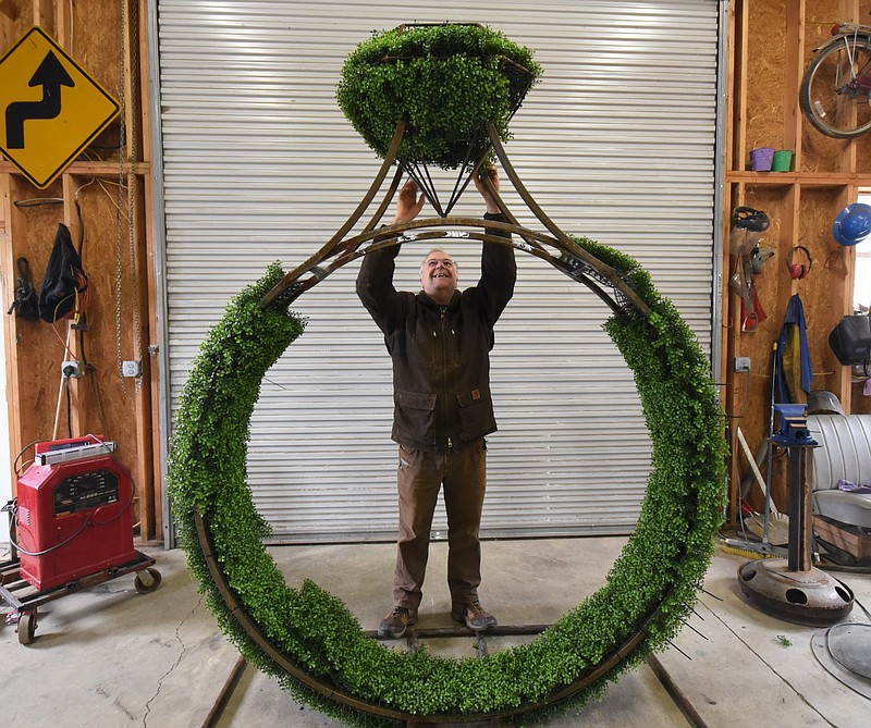 In his workspace in Tellico Plains, Joe Kyte, 56, sets a topiary stone in a design he created for a Knoxville jeweler.