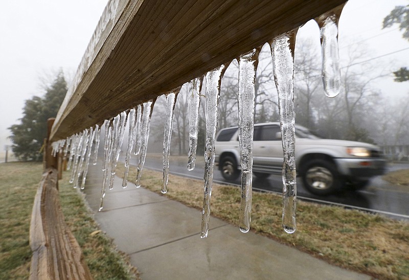 A motorist passes a fence atop Signal Mountain where icicles are forming as rain and freezing temperatures make their way into the Tennessee Valley on Monday, Feb. 16, 2015. 