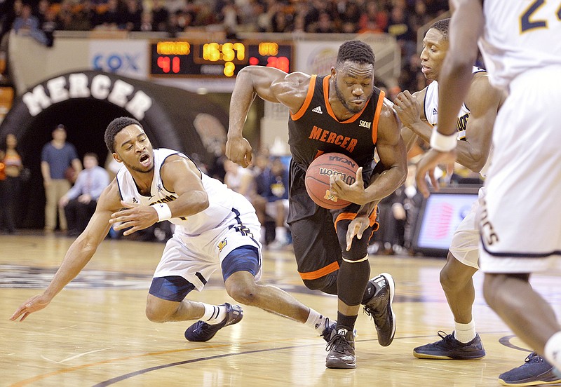 Mercer guard Ike Nwamu (10) attempts to keep possession of the ball while being trapped by UTC defenders during a game in Macon, Ga. 