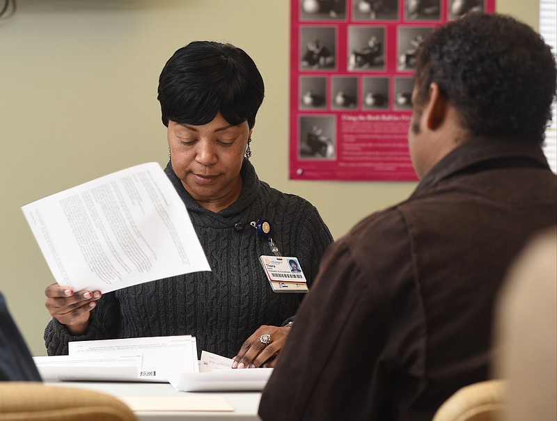 Thera Beaman, left, outreach enrollment specialist at the Dodson Avenue Community Health Center, assists Willie Atkins with Affordable Care Act enrollment on Feb. 10, 2015, in Chattanooga.