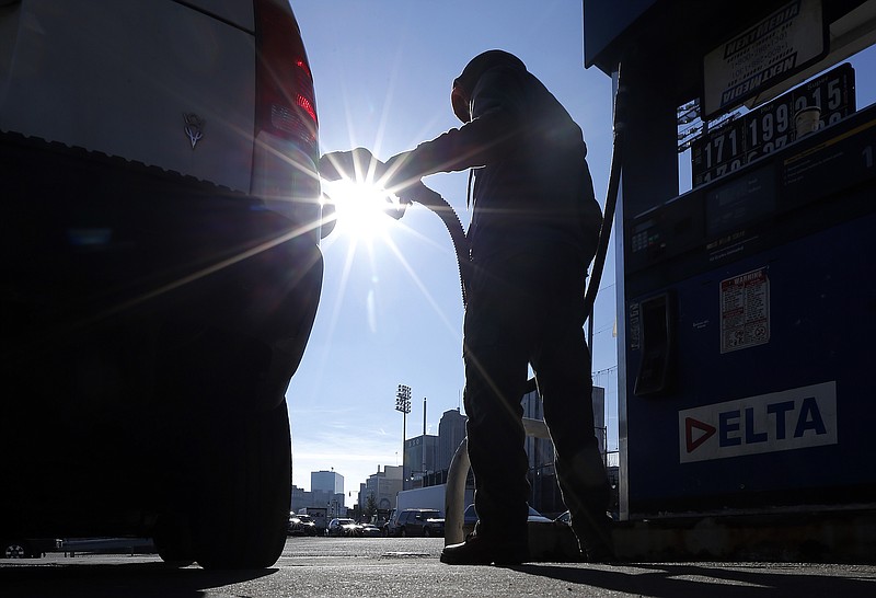 
              FILE - In this Jan. 23, 2015 file photo, Sonu Singh pumps gas for a motorist at a Delta gas station in downtown Newark, N.J., where the cash price for regular unleaded was listed at $1.71. The lowest gas prices in five years had given people more spending money, and hiring was surging. And yet _ to the surprise of analysts _ consumers have held their wallets closely.  (AP Photo/Julio Cortez, File)
            