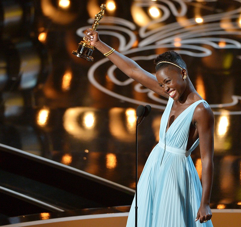 
              FILE - In this March 2, 2014 file photo, Lupita Nyong’o accepts the award for best actress in a supporting role for "12 Years a Slave" during the Oscars in Los Angeles. Nyong’o dazzled Hollywood and the Oscar-viewing public through awards season last year. The Mexican-born, Kenyan-raised actress was a central part last year to an Academy Awards flush with faces uncommon to the Oscar podium. There was Ellen DeGeneres, a proud lesbian, hosting. There was the first Latino, Alfonso Cuaron, winning best director. There was the black filmmaker Steve McQueen hopping for joy after his “12 Years a Slave” won best picture. (Photo by John Shearer/Invision/AP, File)
            