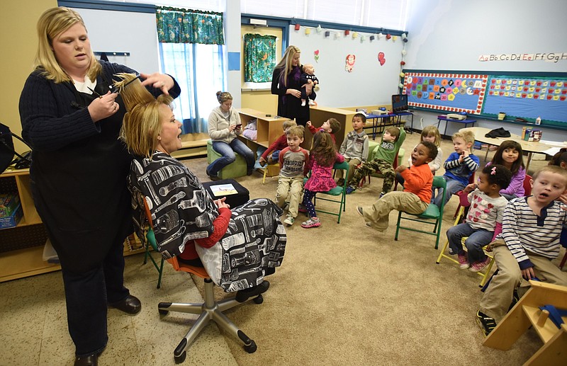 Marty Browning's hair is cut in front of her preschool class.