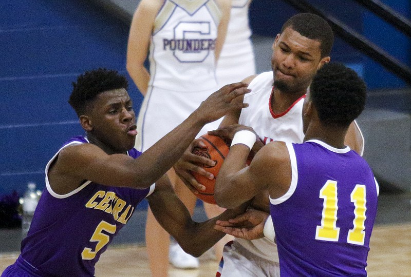 Brainerd's Miles Cothran, center, tries to keep the ball in his arms against Central's Ryan Montgomery, right, and Terron Hayes during their TSSAA District 6-AA basketball championship game Thursday, Feb. 19, 2015, at Red Bank High School in Red Bank.