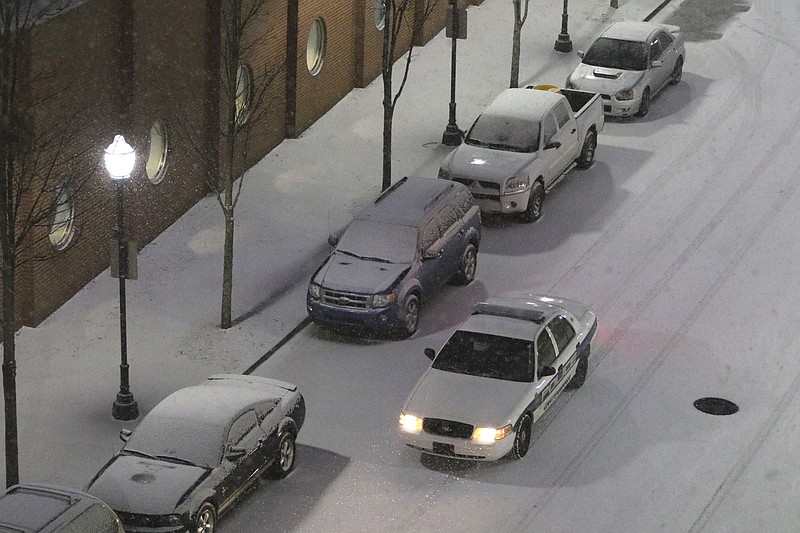 A Chattanooga Police Officer patrols the streets near the IMAX theater as snow falls in downtown Chattanooga, on Friday, February 20, 2015.