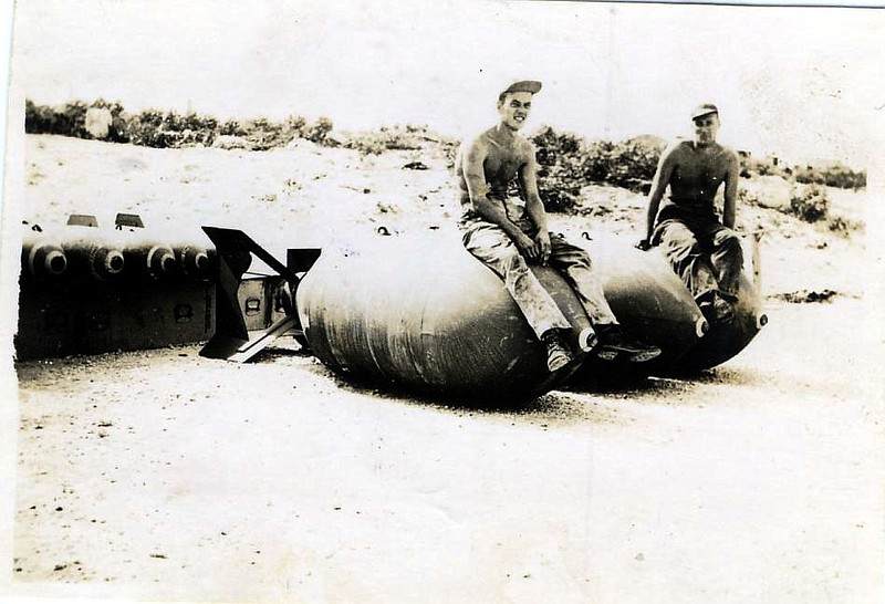 Dan Cooper sits on a 4,000 pound bomb in the Pacific during World War II