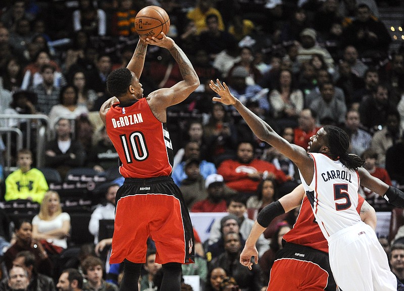 Toronto Raptors guard DeMar DeRozan (10) shoots as Atlanta Hawks forward DeMarre Carroll (5) defends during their game, Friday, Feb. 20, 2015, in Atlanta. 
