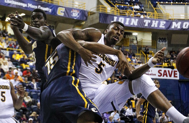 UTC forward Justin Tuoyo (5) tries to rebound the ball against ETSU's Lester Wilson, center, and A.J. Merriweather (13) during the Mocs' Senior Night SoCon basketball game against the ETSU Buccaneers on Saturday, Feb. 21, 2015, at McKenzie Arena in Chattanooga, Tenn.